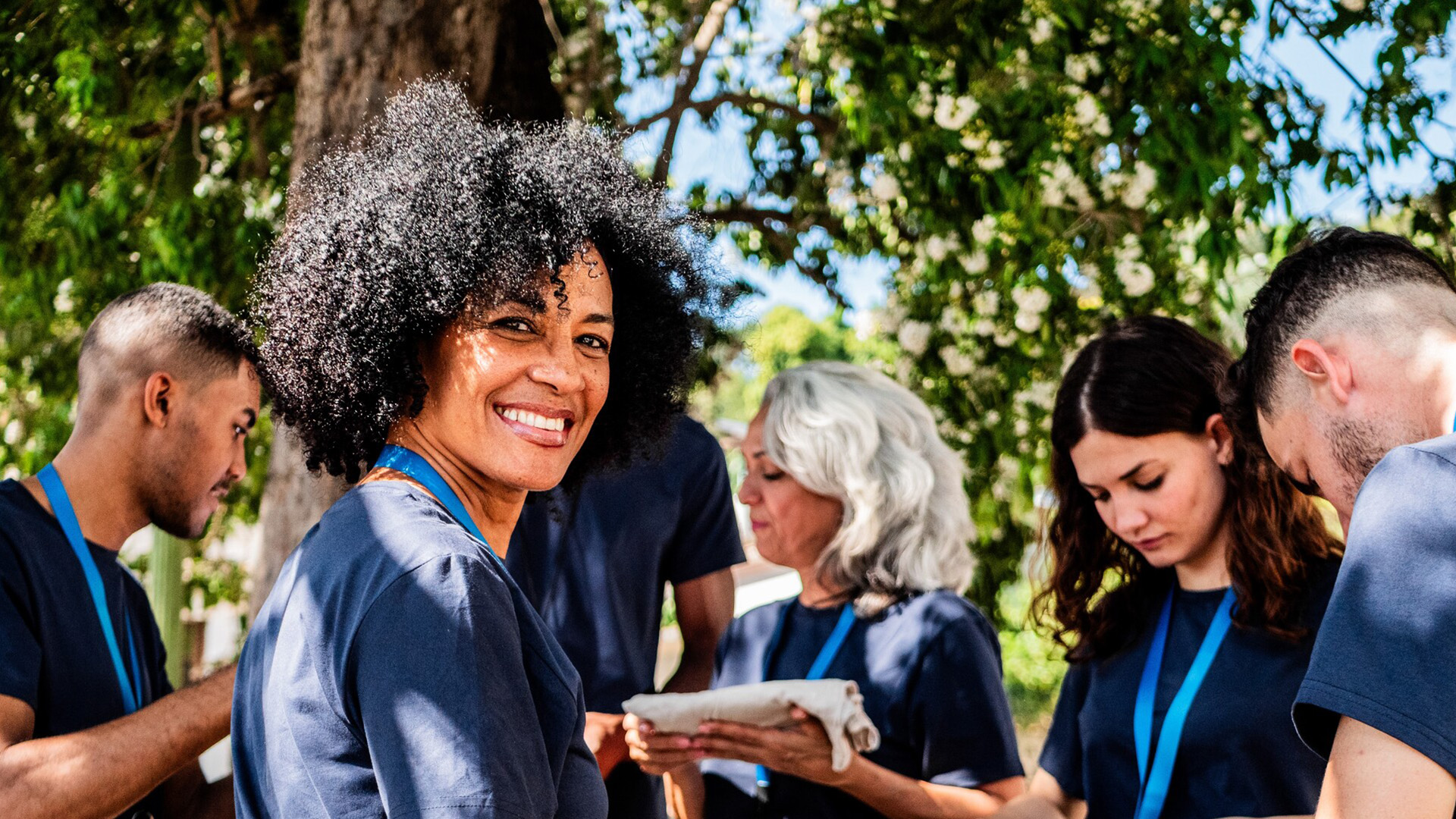 woman smiling and standing in a group of peers